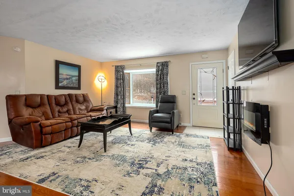 a living room with furniture a flat screen tv and a fireplace