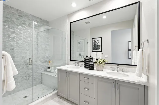 a bathroom with a double vanity sink mirror and shower