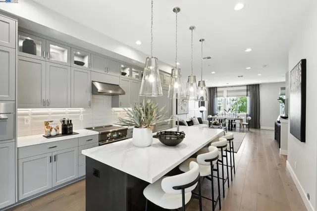 a kitchen with stainless steel appliances a table chairs and white cabinets