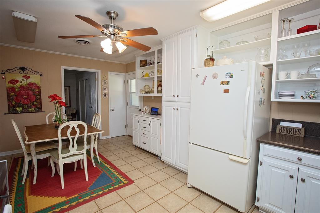 914 Fairview Street Graham, TX 76450 - Photo 4 of 17 a kitchen with stainless steel appliances a stove a refrigerator and a dining table with wooden floor