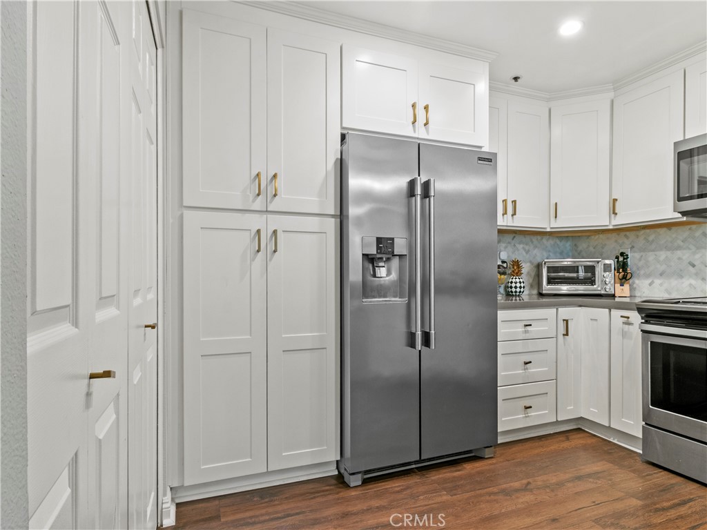 210 Lille Lane, Unit 218 Newport Beach, CA 92663 - Photo 11 of 45 a kitchen with stainless steel appliances granite countertop a refrigerator and a stove top oven