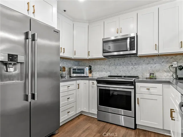 a kitchen with white cabinets and stainless steel appliances