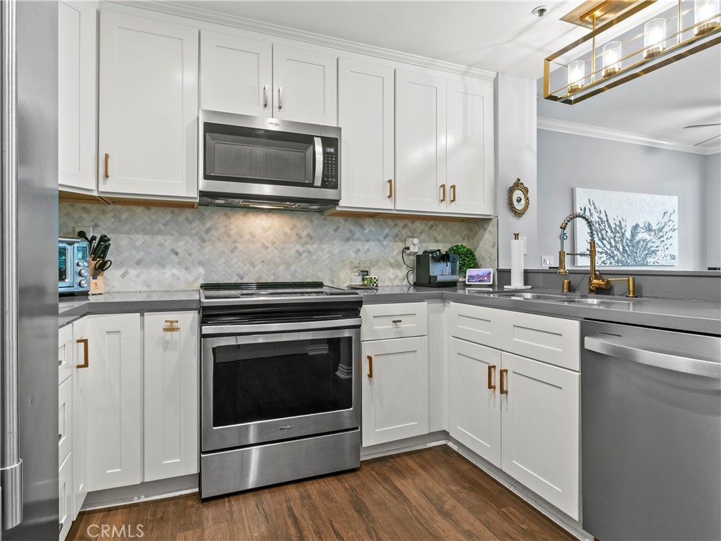 210 Lille Lane, Unit 218 Newport Beach, CA 92663 - Photo 13 of 45 a kitchen with cabinets stainless steel appliances and a sink