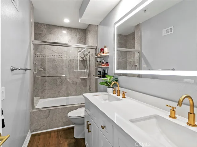 a bathroom with a sink a toilet and shower