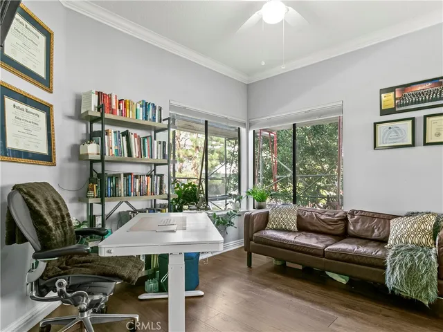 a living room with furniture a bookshelf and a large window
