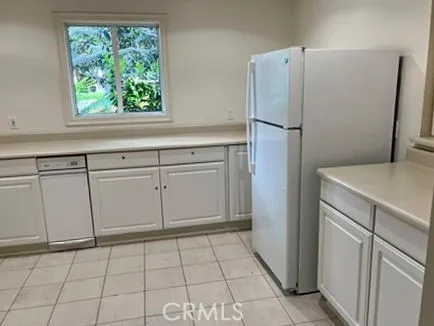 a kitchen with white cabinets and refrigerator