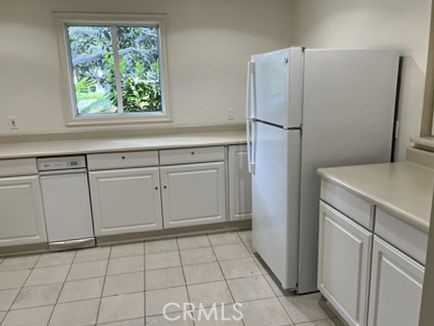 210 Lille Lane, Unit 218 Newport Beach, CA 92663 - Photo 32 of 45 a kitchen with white cabinets and refrigerator