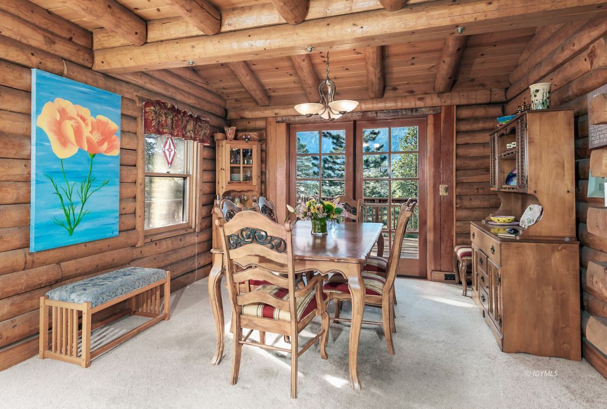25264 Cougar Road Idyllwild, CA 92549 - Photo 15 of 40 a dining room with furniture a floor to ceiling window and a potted plant