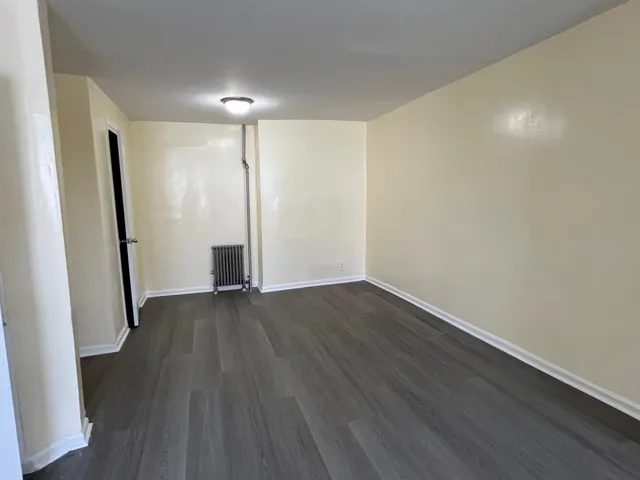 an empty room with wooden floor and glass door