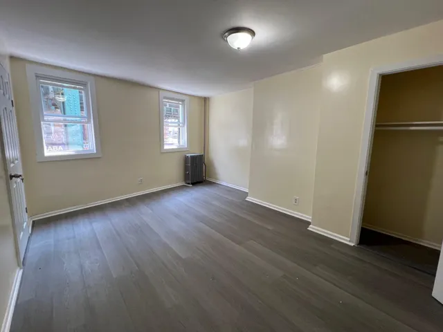 a view of an empty room with wooden floor
