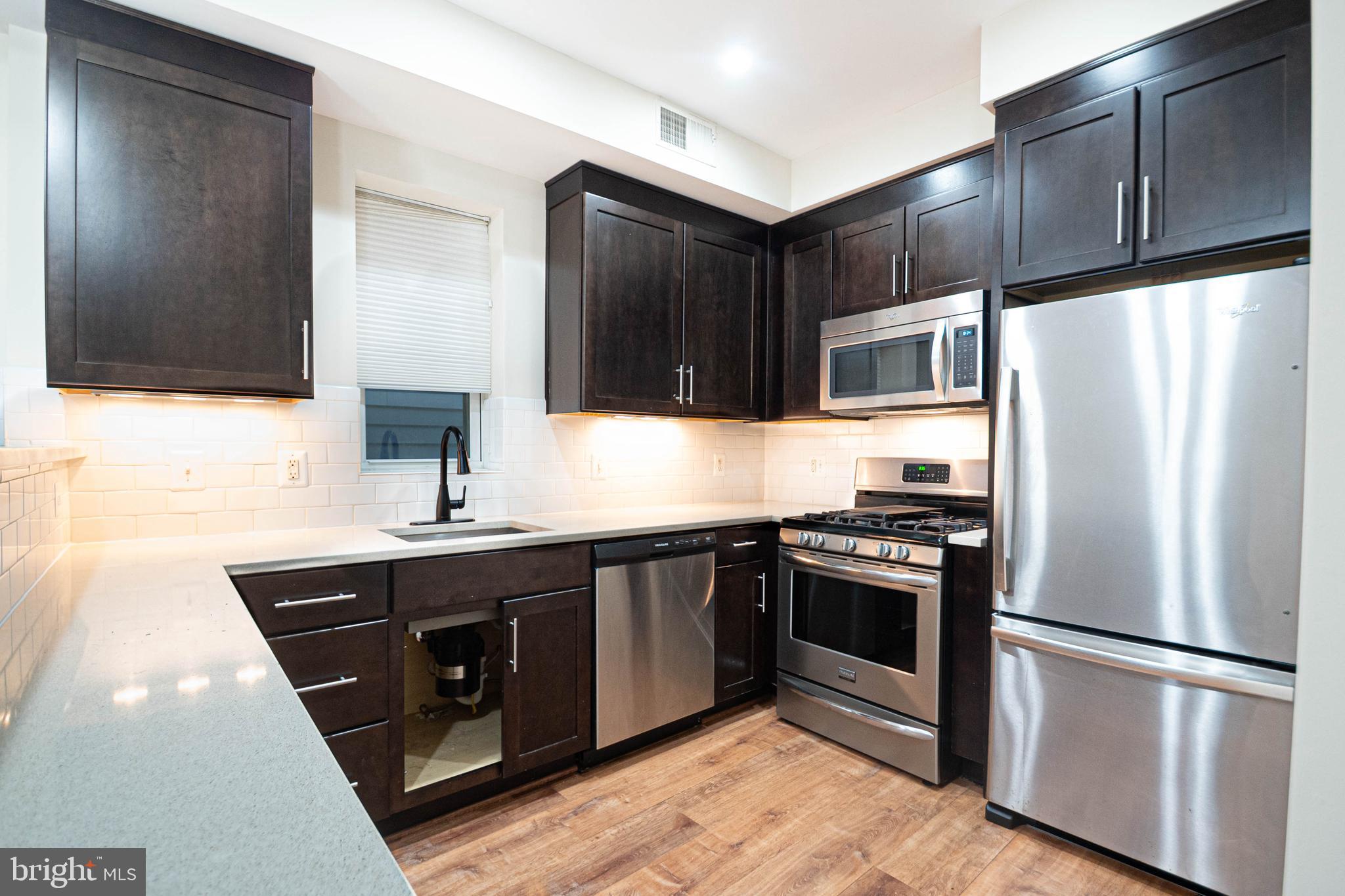 a kitchen with stainless steel appliances granite countertop a stove a refrigerator and a sink