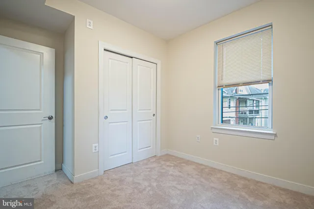 an empty room with windows and closet