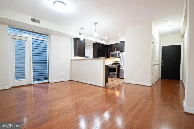 a view of a kitchen with wooden floor and a sink