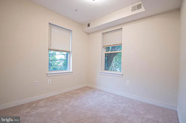 an empty room with windows and closet