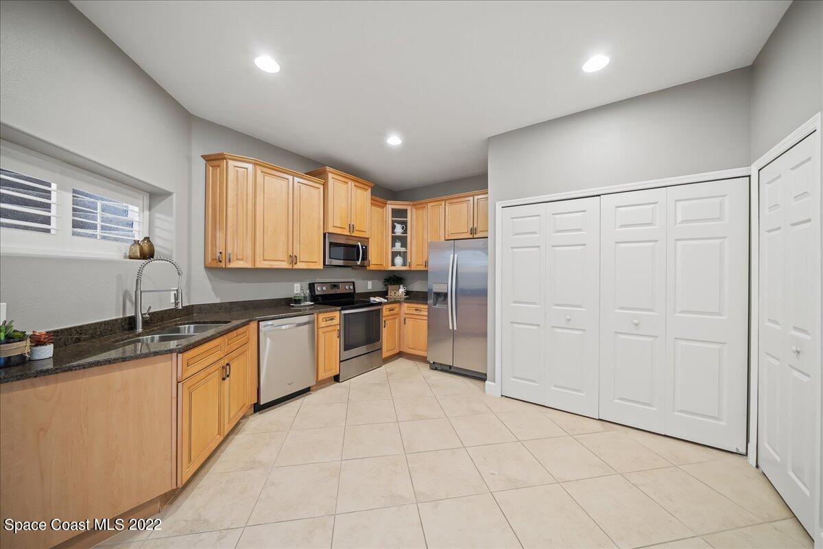 3126 Arden Circle Melbourne, FL 32934 - Photo 11 of 31 a kitchen with granite countertop a sink a counter top space cabinets and stainless steel appliances