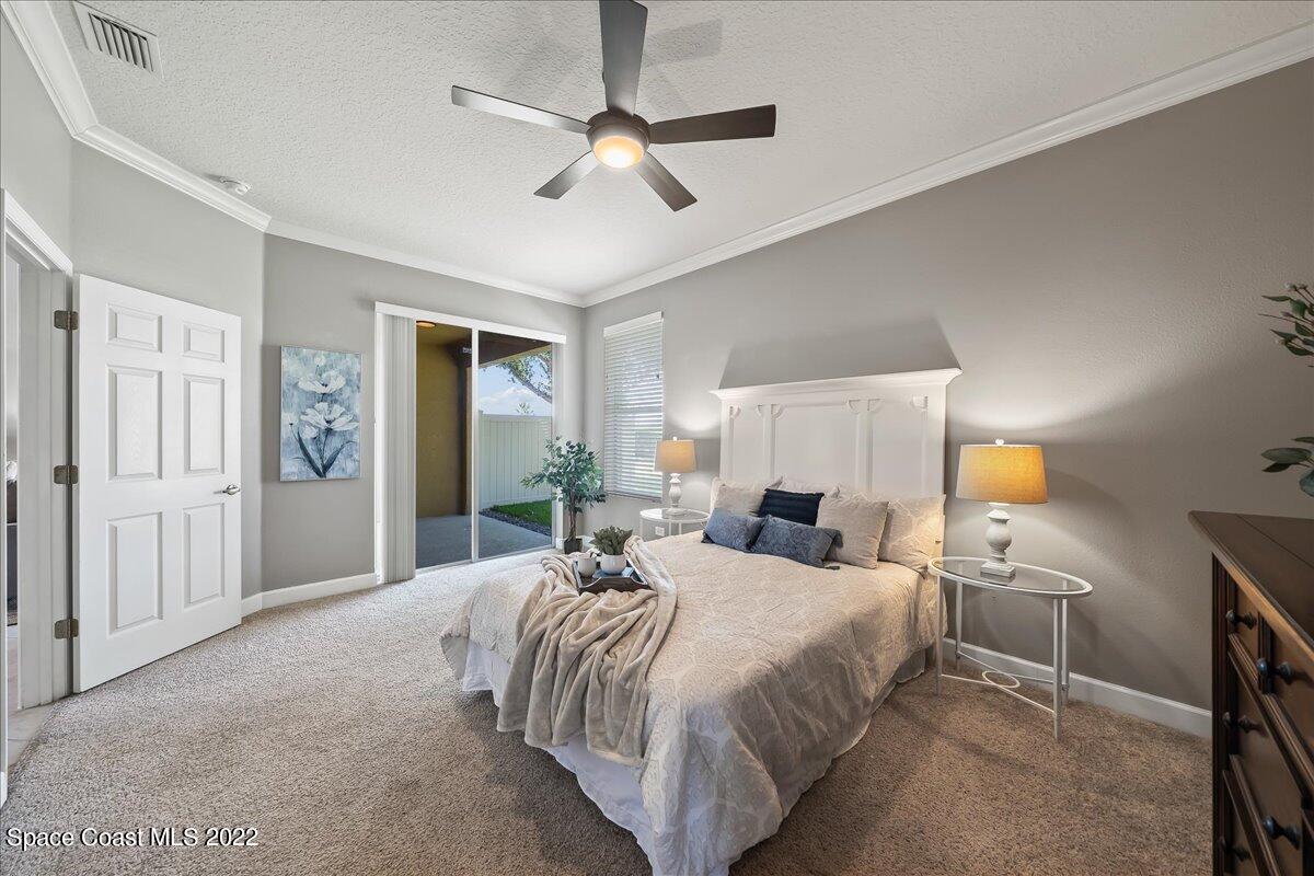 3126 Arden Circle Melbourne, FL 32934 - Photo 15 of 31 a bedroom with a large bed and a chandelier