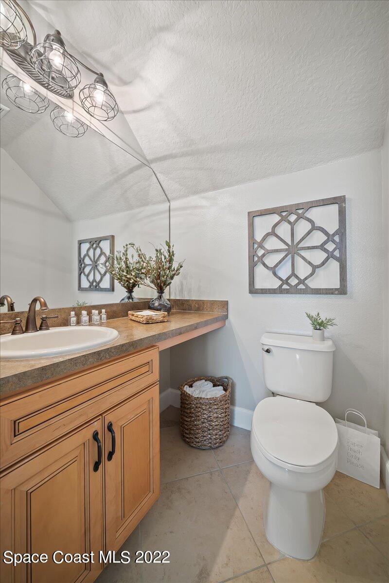 3126 Arden Circle Melbourne, FL 32934 - Photo 16 of 31 a bathroom with a toilet a sink and mirror