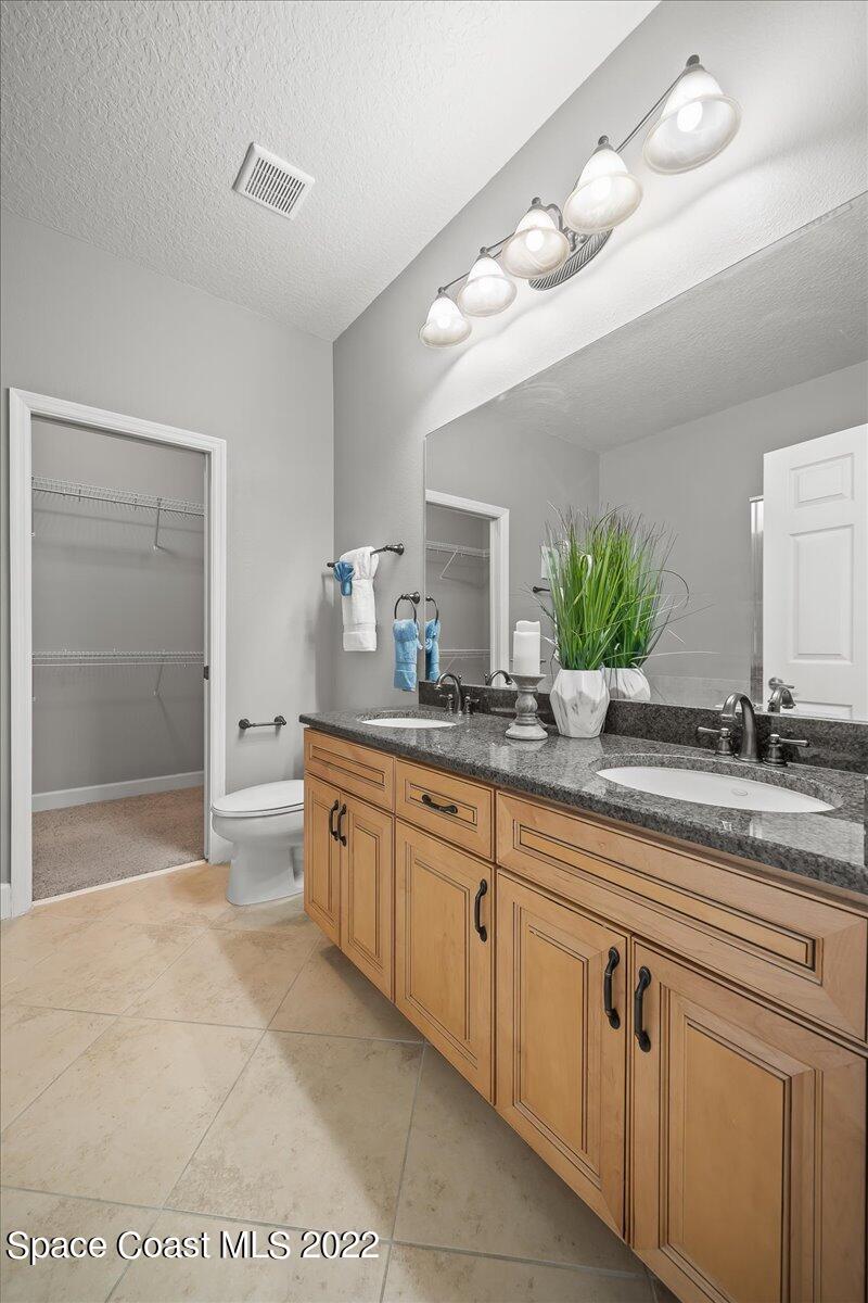 3126 Arden Circle Melbourne, FL 32934 - Photo 17 of 31 a spacious bathroom with a granite countertop sink a mirror and a