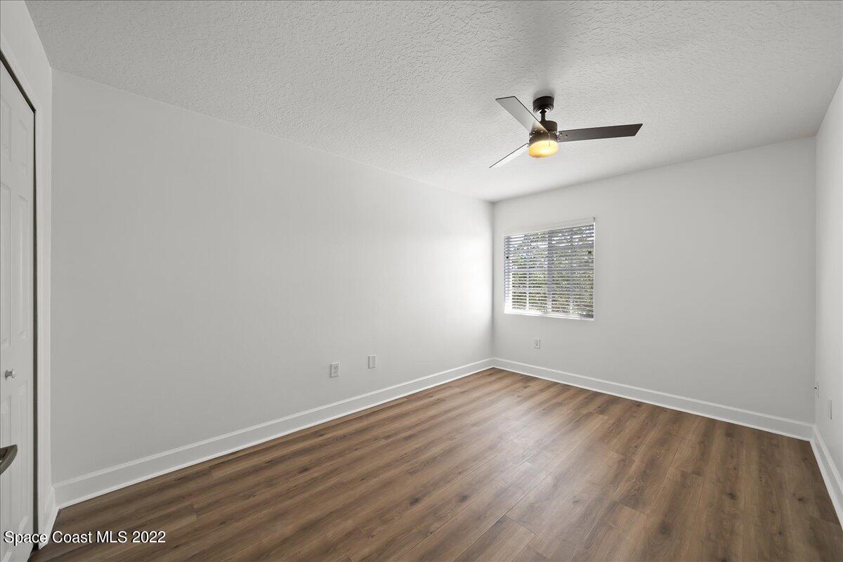 3126 Arden Circle Melbourne, FL 32934 - Photo 24 of 31 an empty room with wooden floor ceiling fan and windows