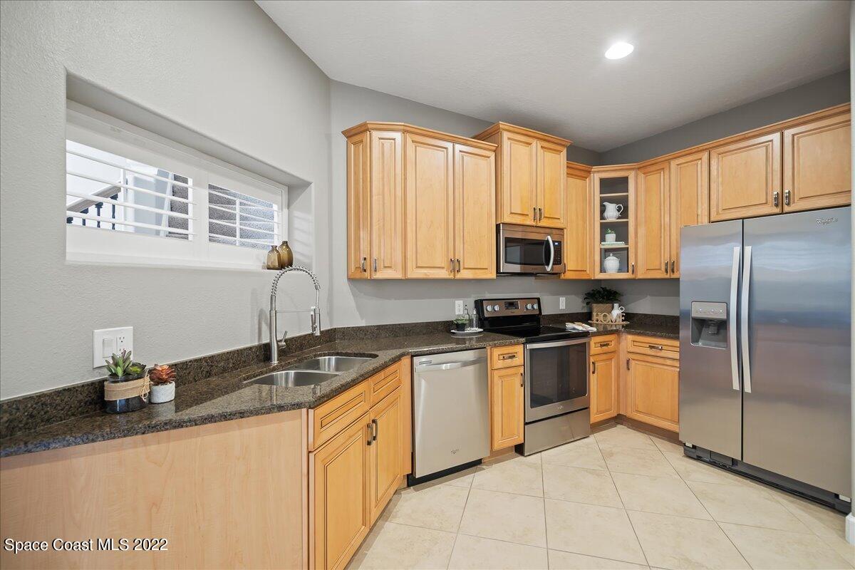 3126 Arden Circle Melbourne, FL 32934 - Photo 10 of 31 a kitchen with stainless steel appliances granite countertop a sink stove and refrigerator