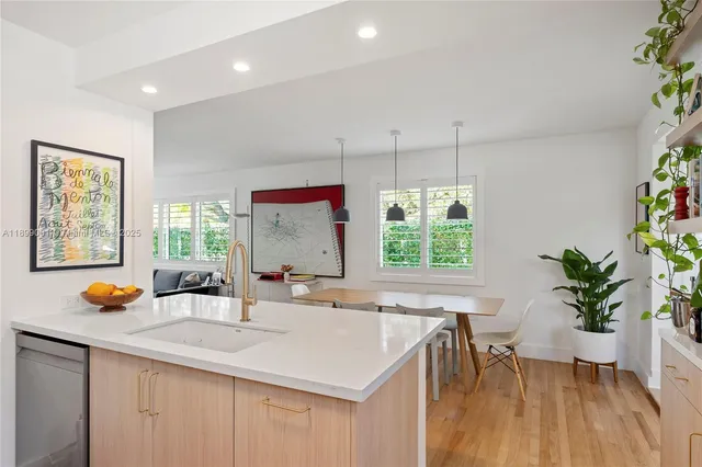 a kitchen with a sink a window and chairs
