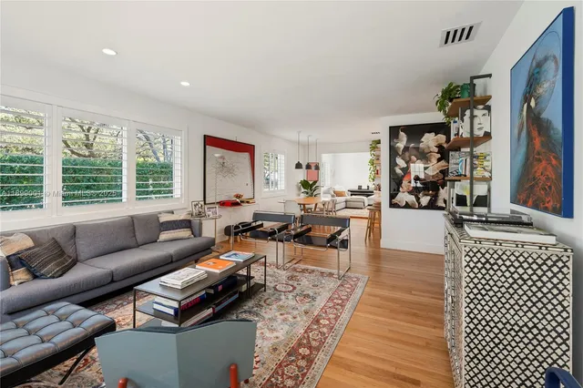 a living room with furniture a rug and a large window