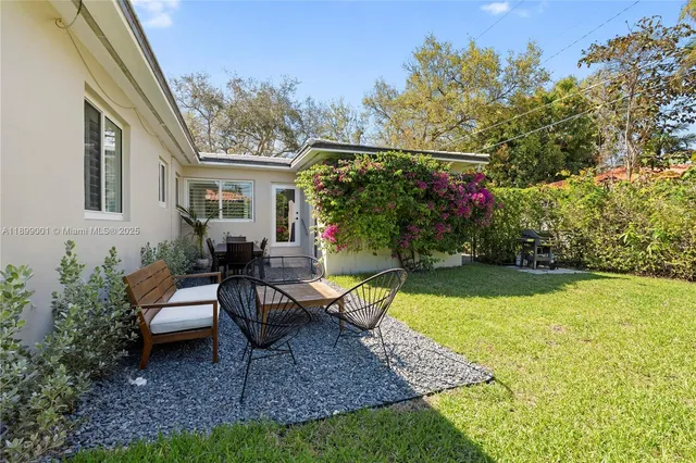 a view of a house with backyard and sitting area