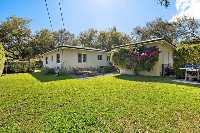 a view of a house with backyard and sitting area