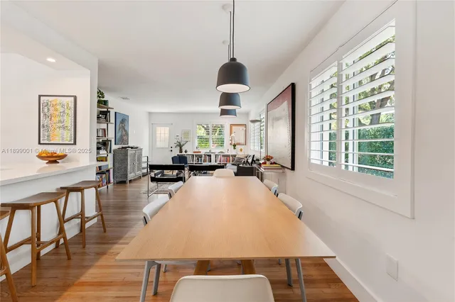 a very nice looking dining room with a large window table and chairs