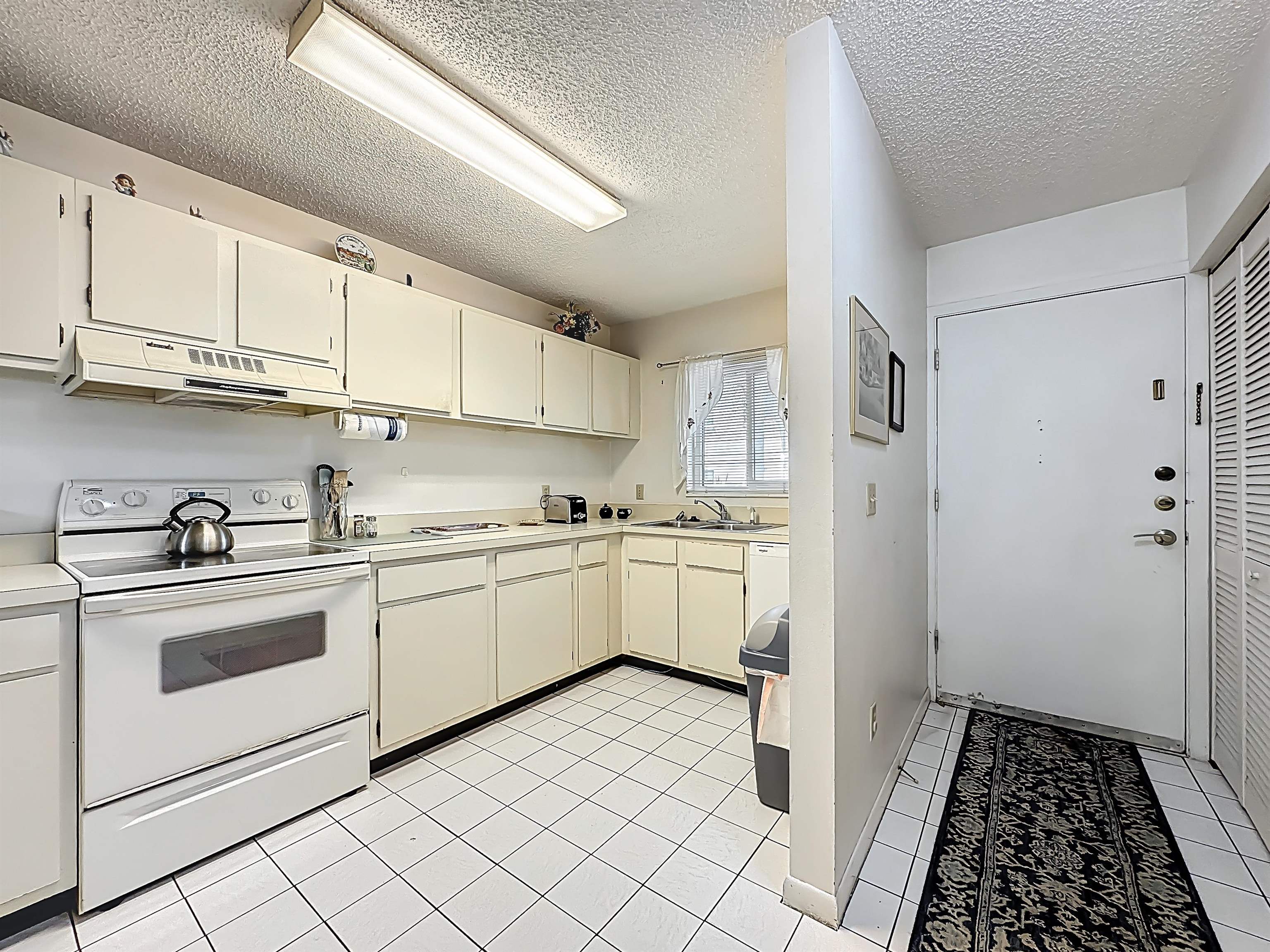 3960 A1A South, Unit 914 St. Augustine, FL 32080 - Photo 4 of 19 a kitchen with white cabinets and white appliances