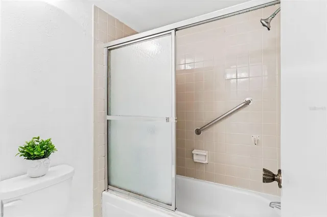 an empty room with a ceiling fan and closet area