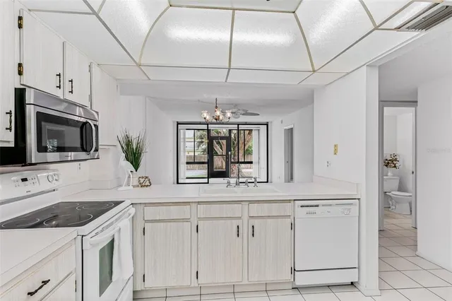 a kitchen with white cabinets and appliances