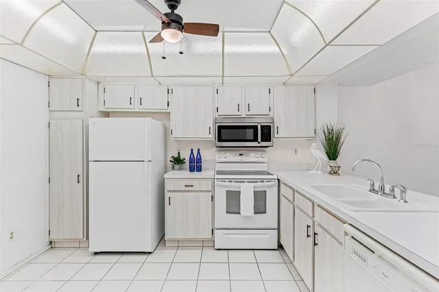 a kitchen with cabinets appliances a sink and a counter top space