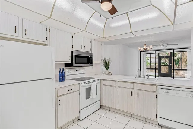 a kitchen with white cabinets sink and white appliances