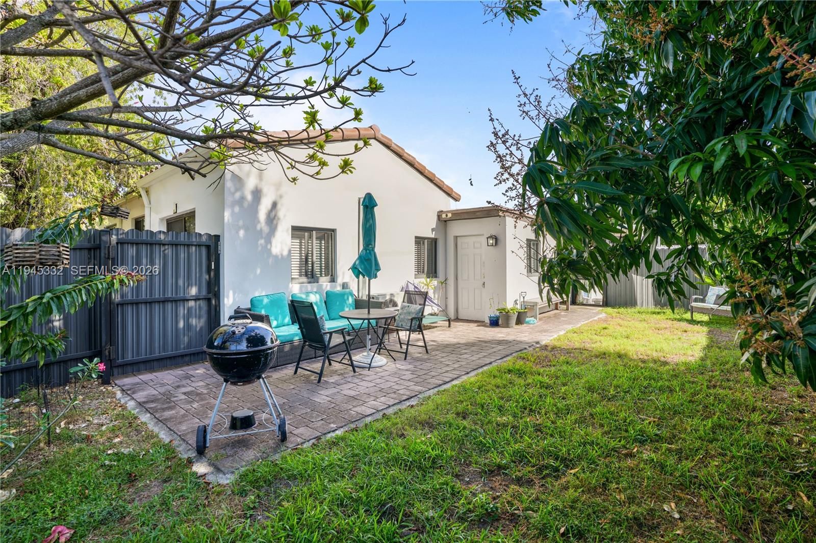 2290 Southwest 2nd Terrace Miami, FL 33135 - Photo 24 of 60 a view of a backyard with table and chairs potted plants and large tree
