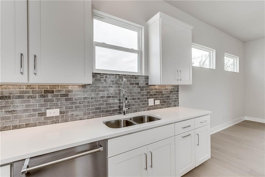 5002 Pecan Springs Road, Unit 10 Austin, TX 78723 - Photo 6 of 29 Kitchen with a sink, decorative backsplash, dishwasher, and light countertops