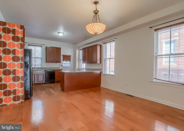 a kitchen with stainless steel appliances granite countertop a sink a stove a refrigerator cabinets and a window