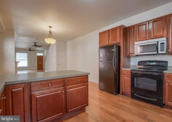 a kitchen with granite countertop a refrigerator stove and microwave