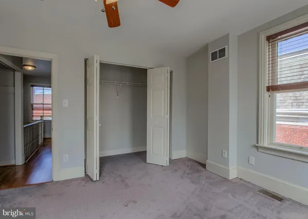 an empty room with windows and closet