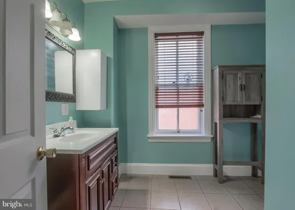 a bathroom with a sink vanity and a mirror