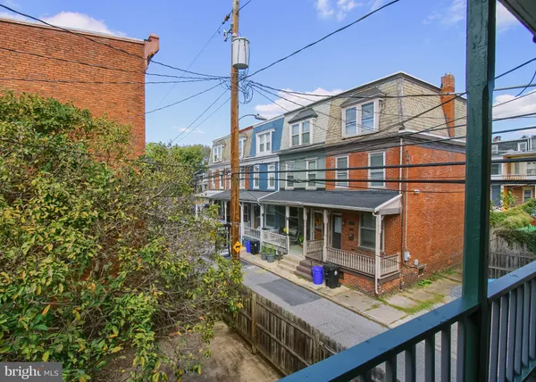 a view of a brick house with large windows and a small yard