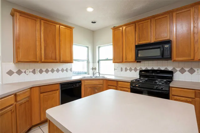 a kitchen with granite countertop wooden cabinets and a stove top oven