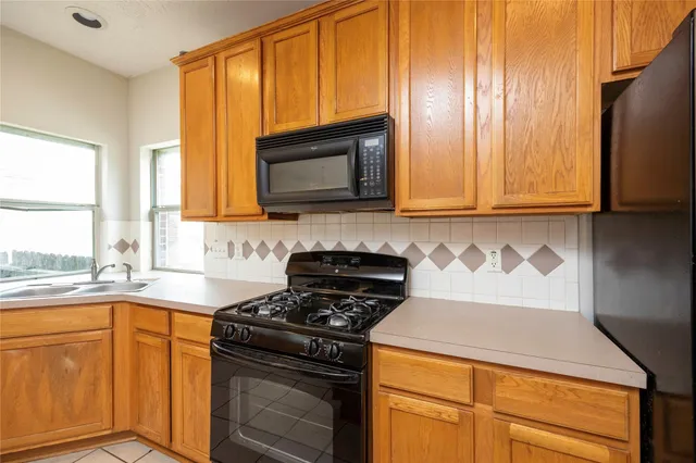 a kitchen with granite countertop cabinets stainless steel appliances a sink and a window
