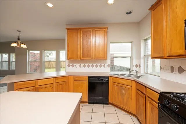 a large kitchen with granite countertop a sink dishwasher stove and cabinets