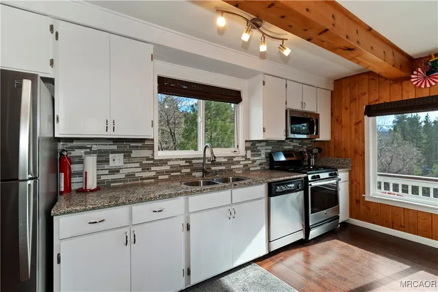 a kitchen with stainless steel appliances granite countertop a stove a sink and a refrigerator