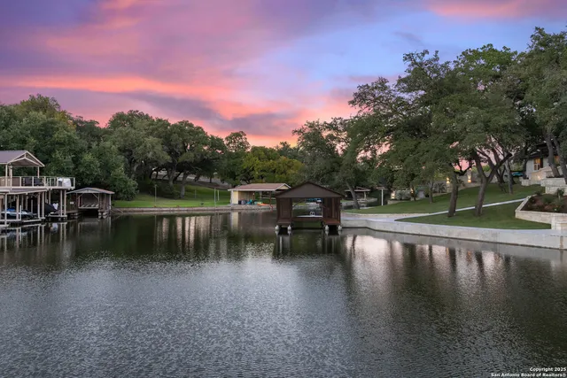 a view of swimming pool with outdoor seating and lake in the back