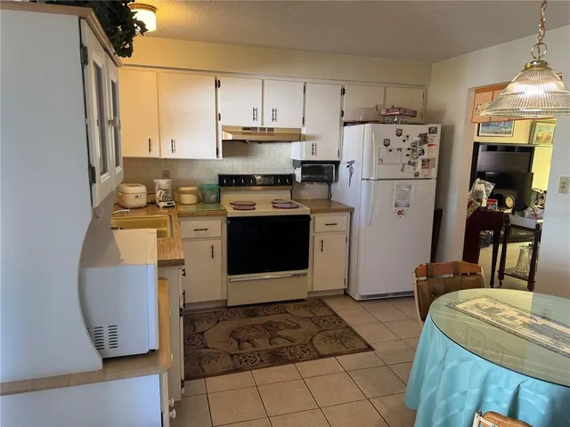 a kitchen with stainless steel appliances kitchen island granite countertop a refrigerator a stove top oven a sink and dishwasher