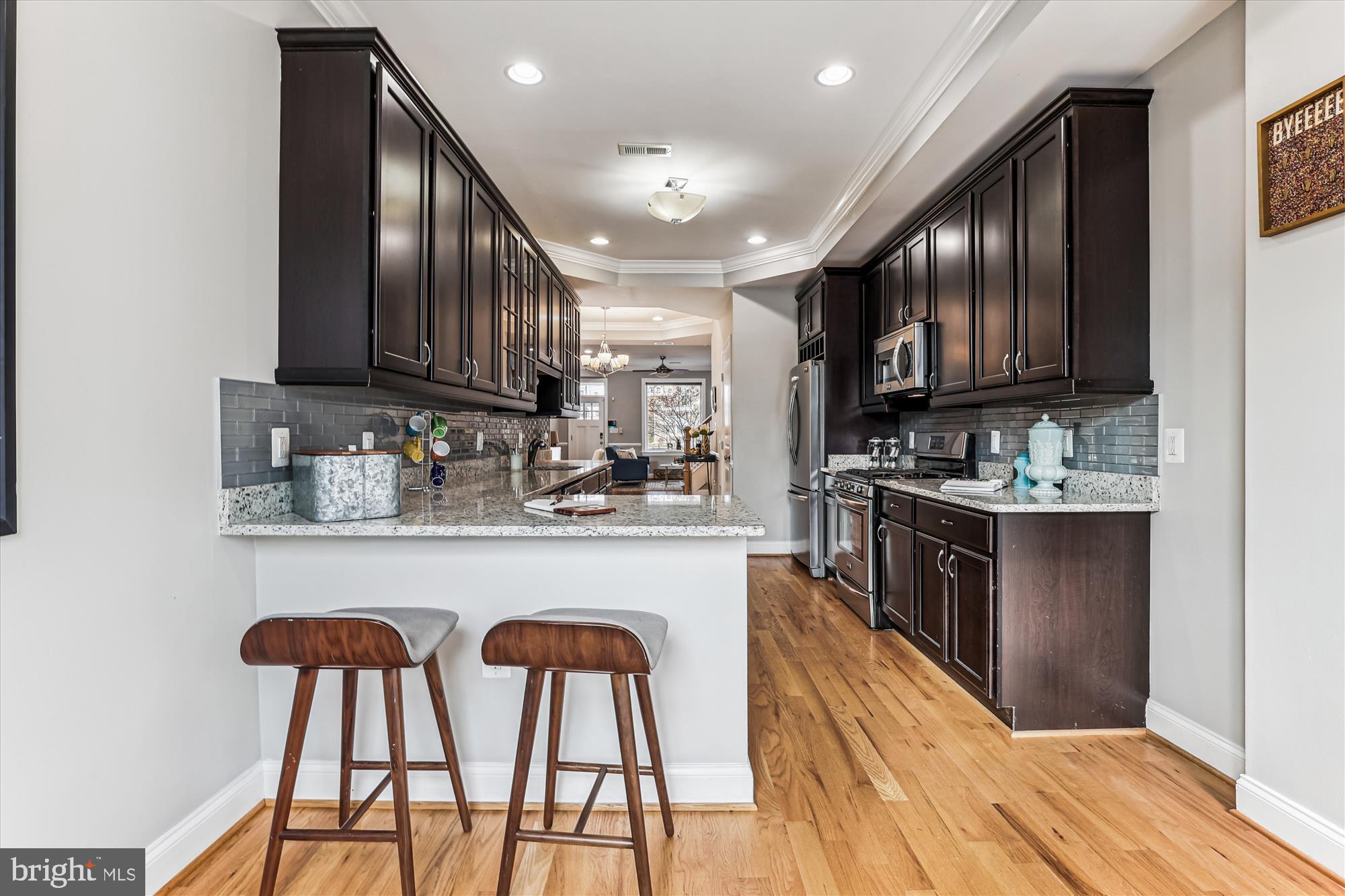 1114 Spring Road Northwest Washington, DC 20010 - Photo 17 of 142 a kitchen with stainless steel appliances granite countertop wooden cabinets refrigerator dining table and chairs