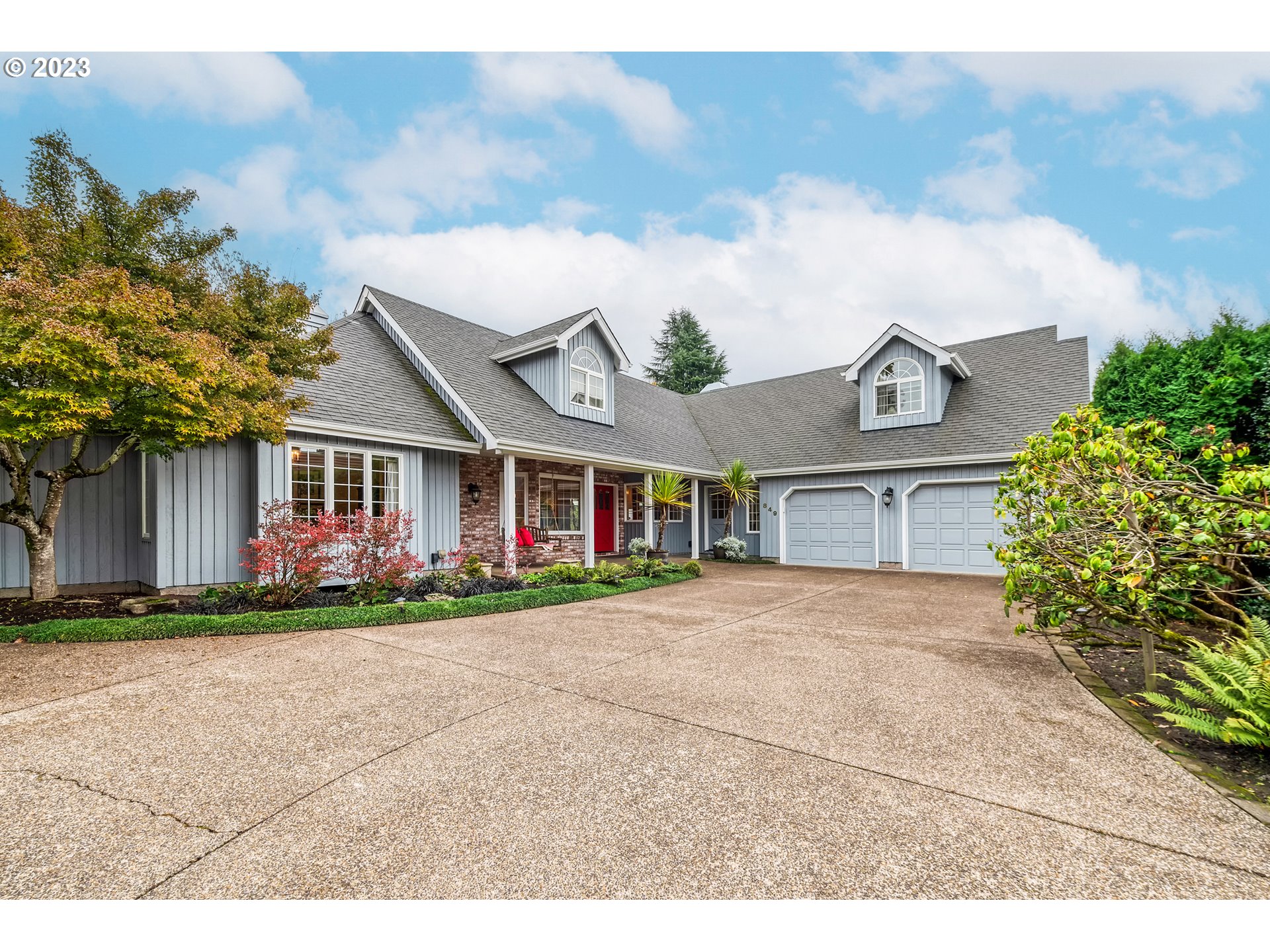 849 Fairway View Drive Eugene, OR 97401 - Photo 4 of 47 a view of a white house with large windows and a yard with plants and large trees