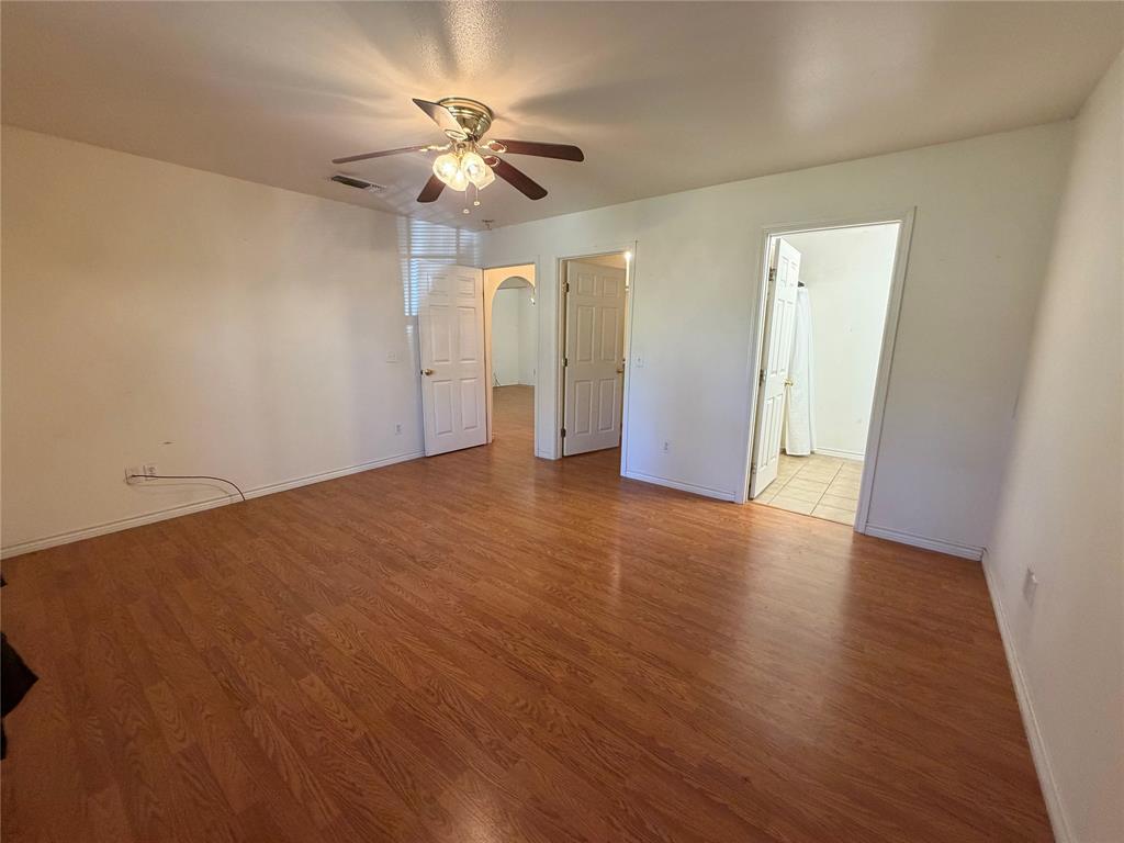 2502 Davisville Road Lufkin, TX 75901 - Photo 15 of 30 an empty room with wooden floor chandelier fan and windows